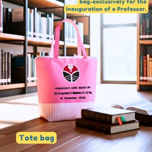 Tote Bag Custom Onnellinen warna pink cerah untuk Pengukuhan Guru Besar UPI, diletakkan di rak buku, menunjukkan refinded commemorative tote bag.