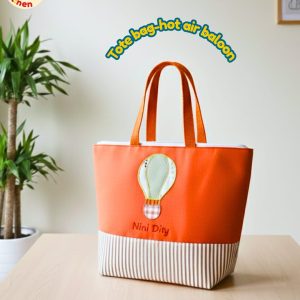 Totebag anak warna cerah dengan aplikasi kain gambar balon udara warna-warni dan bordir nama anak.